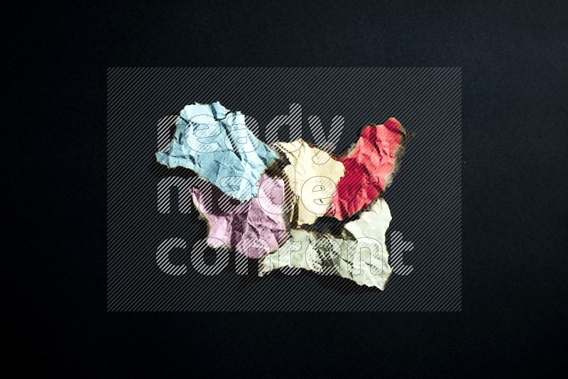 Burnt multicolored paper on black background