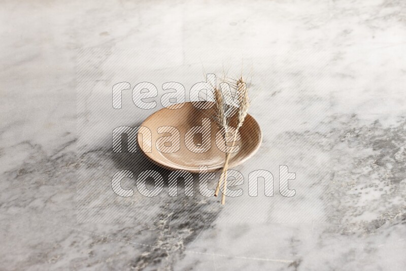 Wheat stalks on Beige Pottery Plate on grey marble flooring, 45 degree angel