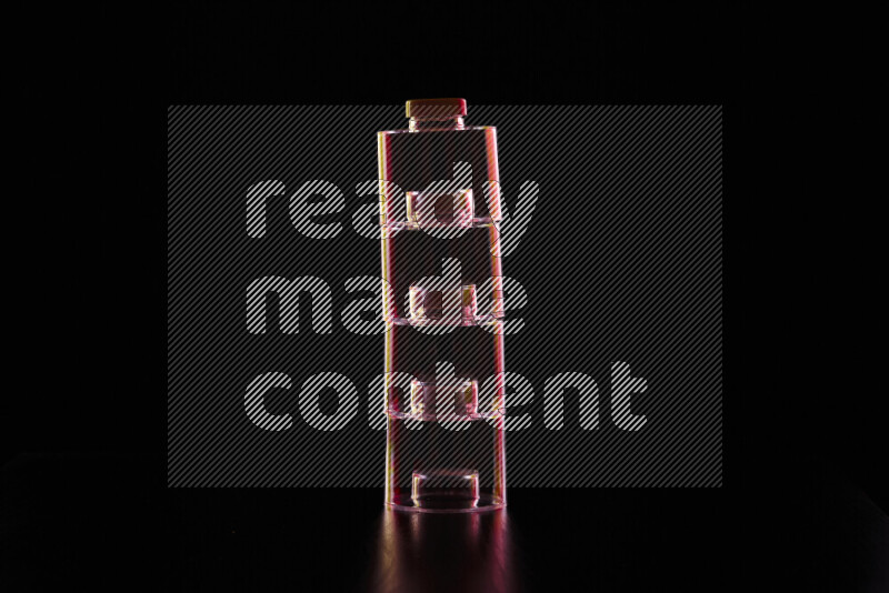 Glassware with rim light in red and yellow against black background