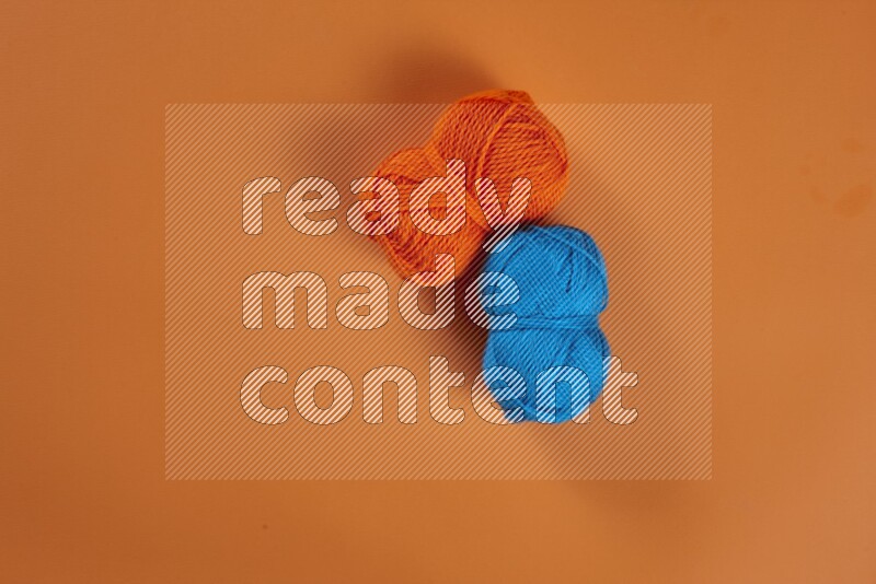 A blue collection of sewing and tailoring tools arranged on a orange background