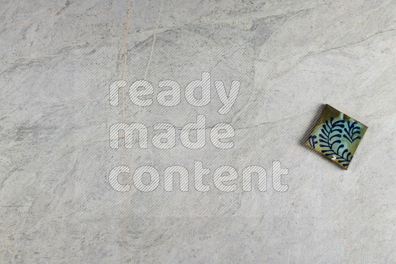 Top View Shot Of A Pottery Coaster tile On Grey Marble Flooring