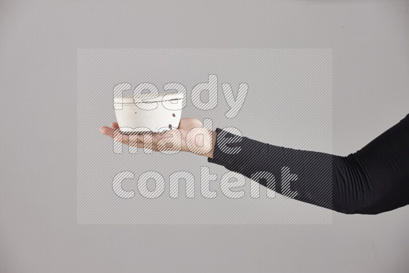 امرأة ترتدي عباءة سوداء تحمل أدوات فخارية مختلفة في أوضاع متعددة