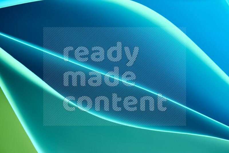 هذه الصورة تعرض تكوين فن الورق التجريدي مع منحنيات ورقية بتدرجات اللون الأخضر والأزرق المكونه بواسطة الضوء الملون