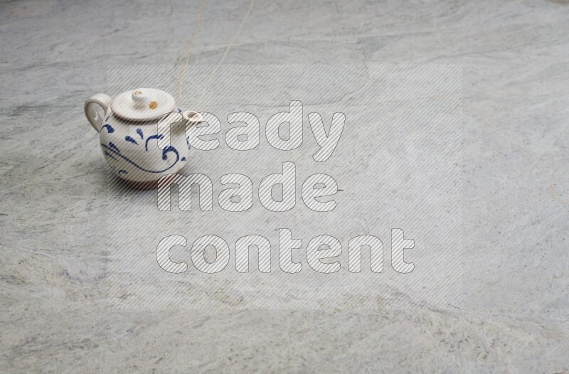 A pottery teapot on grey marble background