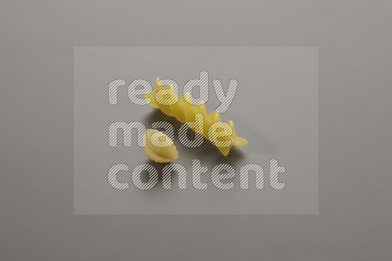 Shells pasta with other types of pasta on grey background