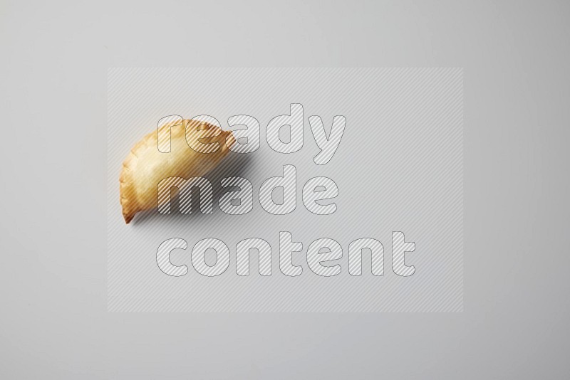 One fried sambosa from a top angle on a white background