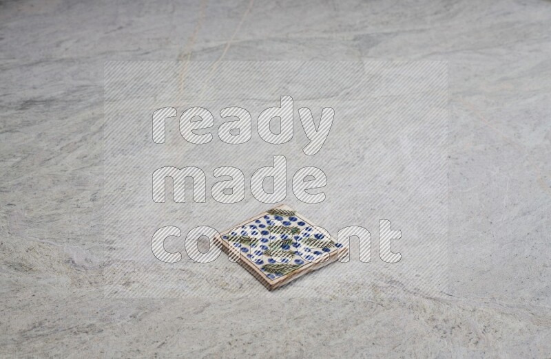 Top view shot of a pottery coaster\ tile on beige marble flooring