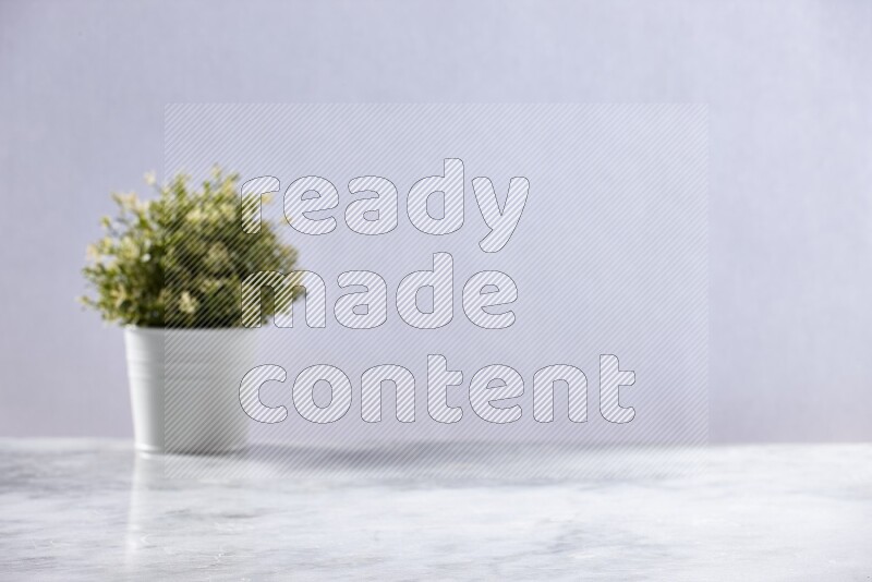 Artificial plant in white pot on grey marble background