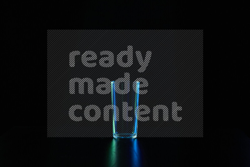 Glassware with rim light in blue and green against black background