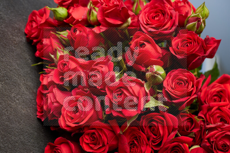 A luxurious bouquet of red roses on black marble background