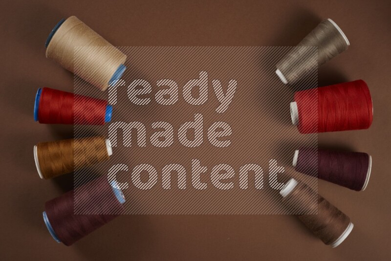 مجموعة من أدوات الخياطة والتفصيل حمراء اللون على خلفية بنية