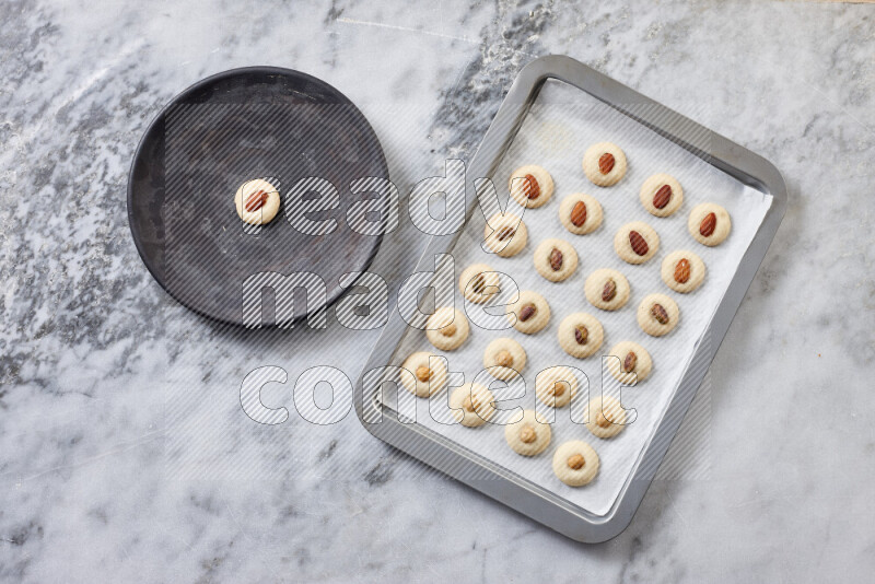 غريبة خطوة بخطوة بالمكونات الدقيق والسكر البودرة والسمن والمكسرات على خلفية رخام رمادي