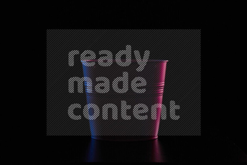 A plant pot with colored rim light against black background