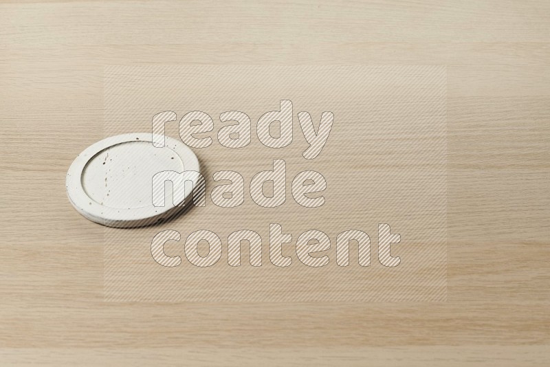 Flat pottery plate coaster on oak wooden flooring, 45 degrees