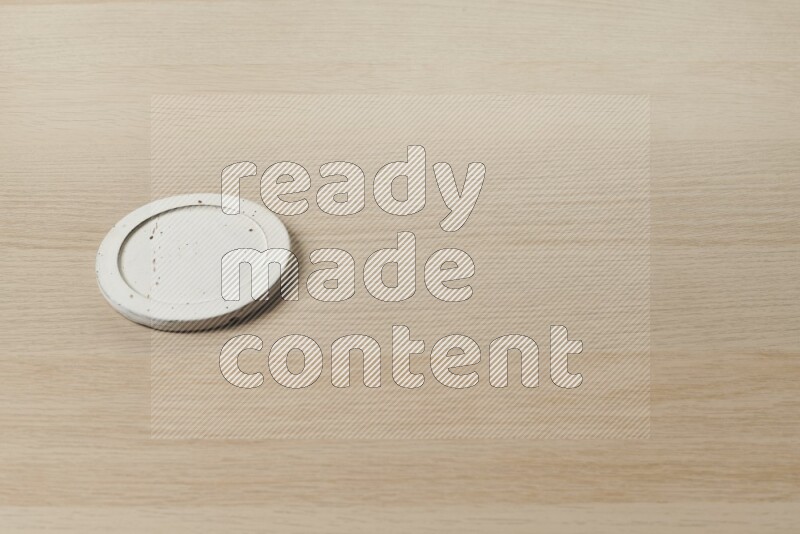A pottery coaster on light wooden background