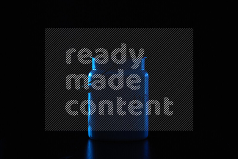 A vintage milk canister with colored rim light against black background