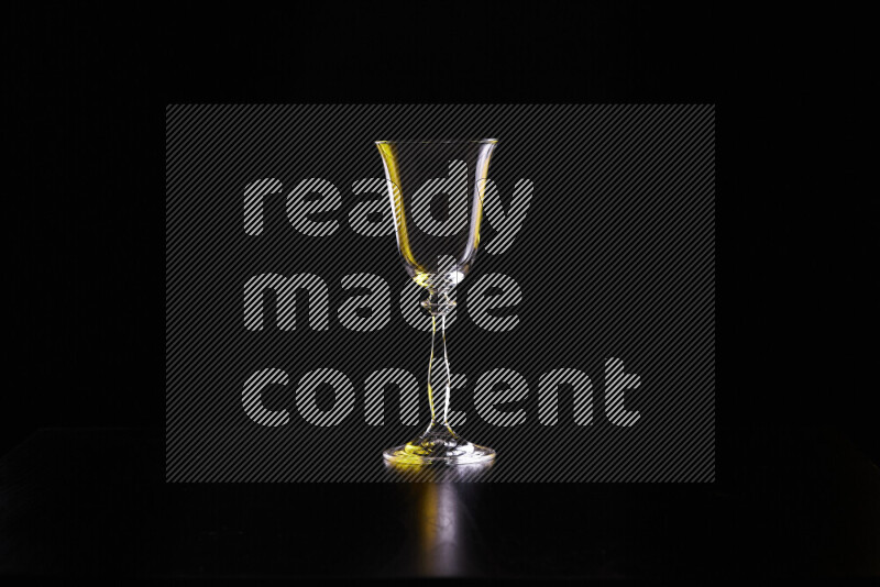 Glassware with rim light in yellow and white against black background