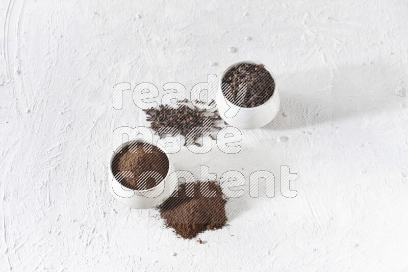 وعاءين من السيراميك بيج اللون، أحدهما مملوء بالقرنفل والآخر مملوء بالبودرة على أرضية بيضاء