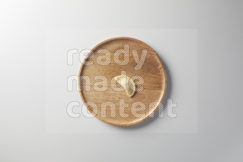 A single Sambosa on a wooden round plate on a white background