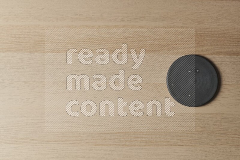 A pottery coaster on light wooden background