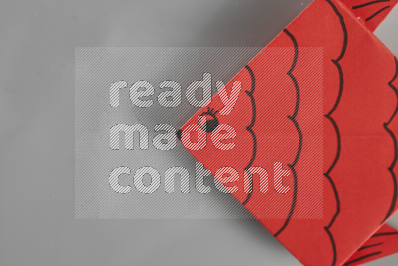 Origami fish on grey background