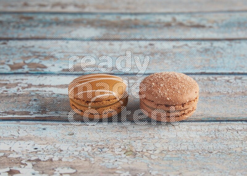 45º Shot of of two assorted Brown Irish Cream, and Brown Hazelnuts macarons  on light blue background