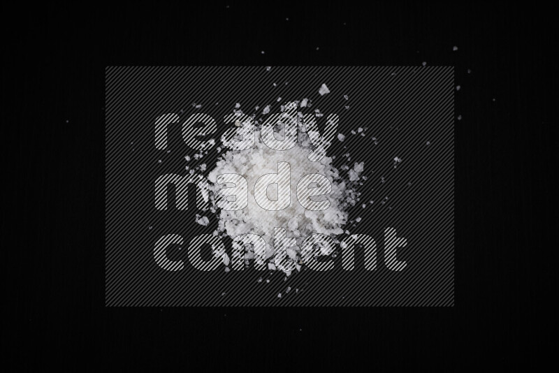 A bunch of coarse sea salt crystals on black background