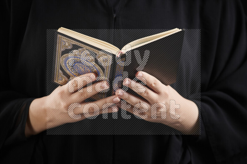 امرأة تحمل بيديها مصحف القرآن في أوضاع متعددة