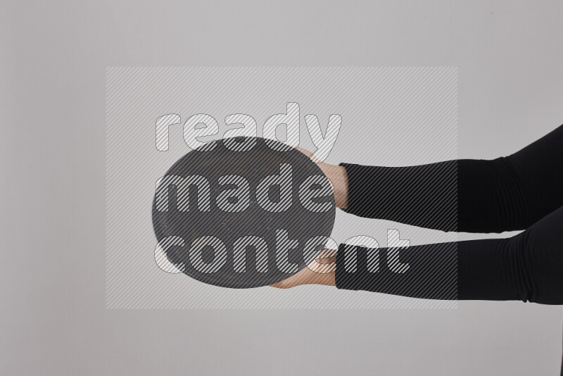 امرأة ترتدي عباءة سوداء تحمل أدوات فخارية مختلفة في أوضاع متعددة