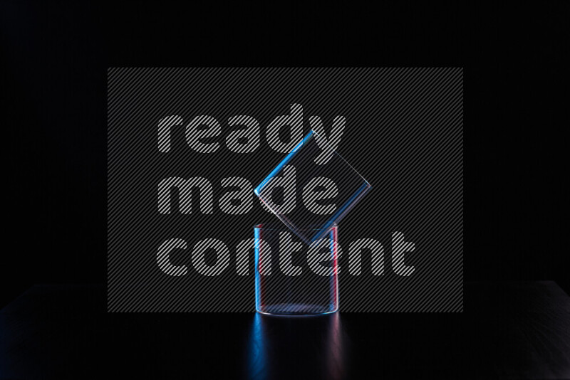 Glassware with rim light in red and blue against black background