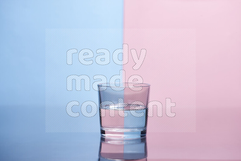 The image features a clear glassware filled with water, set against light blue and rose background