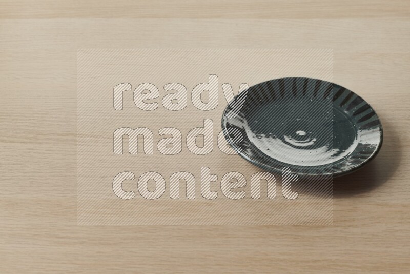 A multicolored pottery plate on light wooden background