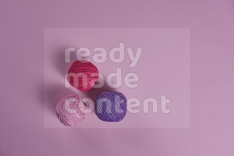 A purple and pink collection of sewing and tailoring tools arranged on a pink background