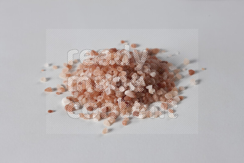 A bunch of coarse himalayan salt crystals on white background