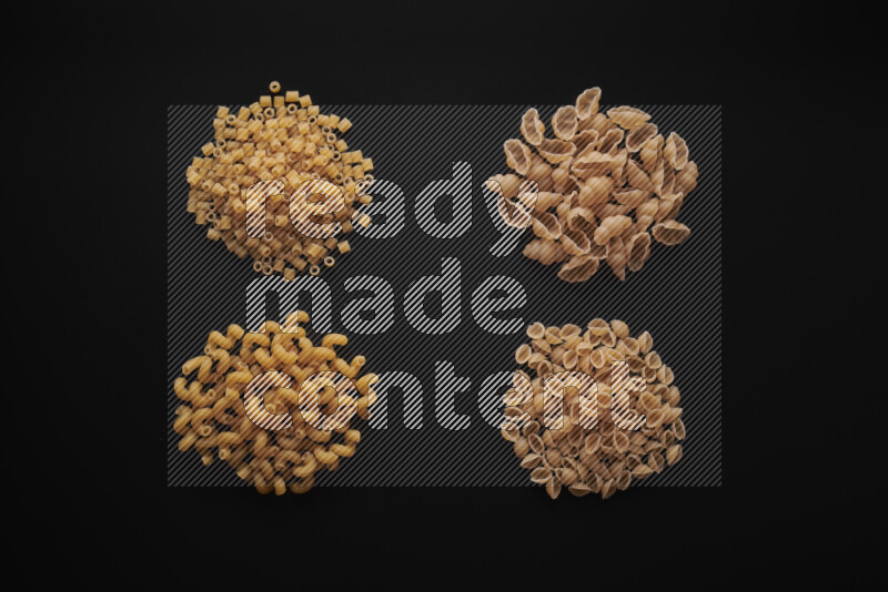 Different pasta types in bunches on black background