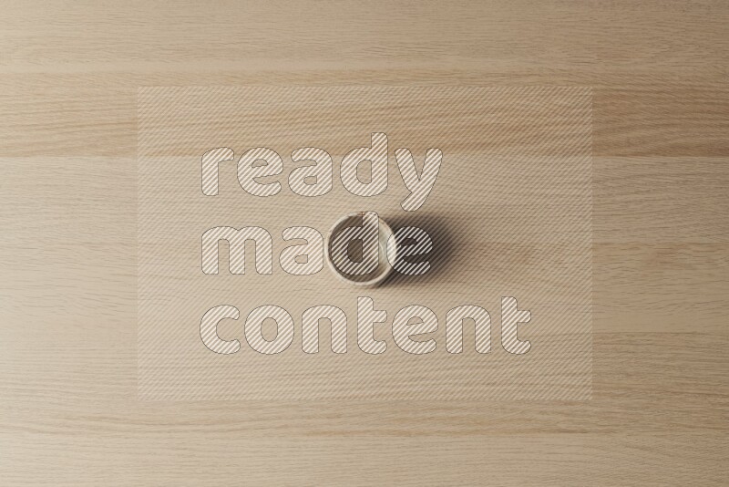 A pottery cup on light wooden background