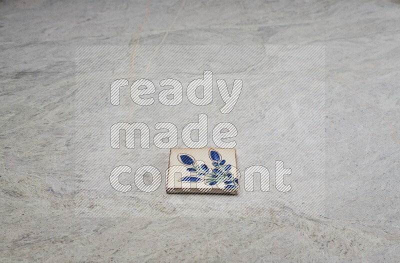 Top view shot of a pottery coaster\ tile on beige marble flooring