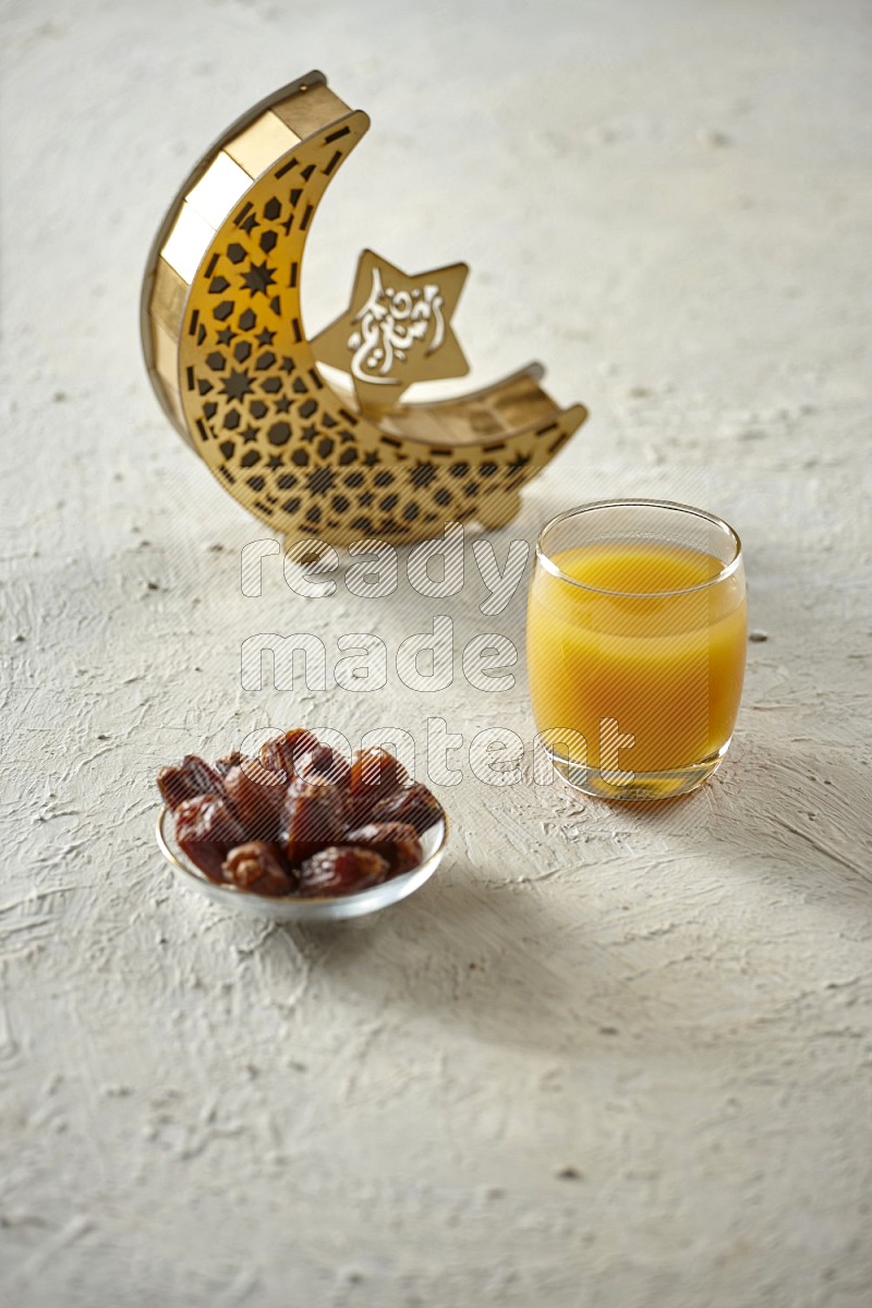 A wooden golden crescent lantern with different drinks, dates, nuts, prayer beads and quran on white background