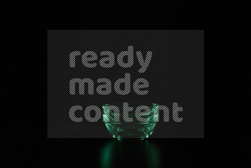 Glassware with rim light in green against black background