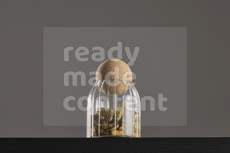 Turmeric in a glass jar on black background