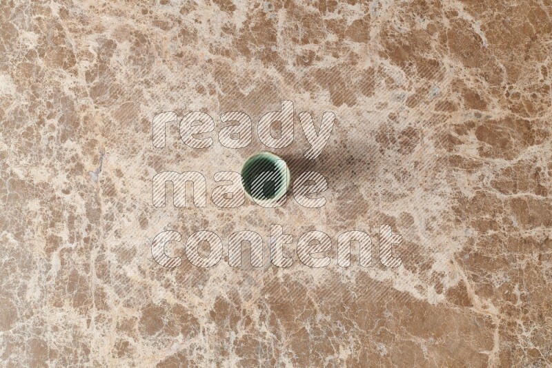 A pottery cup on beige marble background