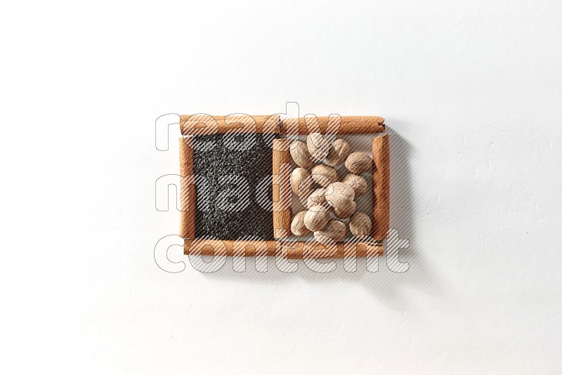 2 squares of cinnamon sticks full of black seeds and nutmeg on white flooring