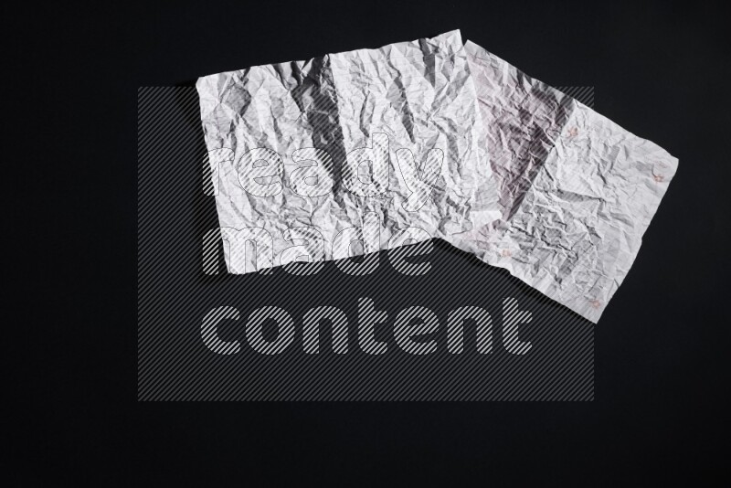 Crumpled notebook sheet on black background