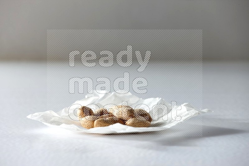 Almonds on a crumpled piece of paper on a white background in different angles