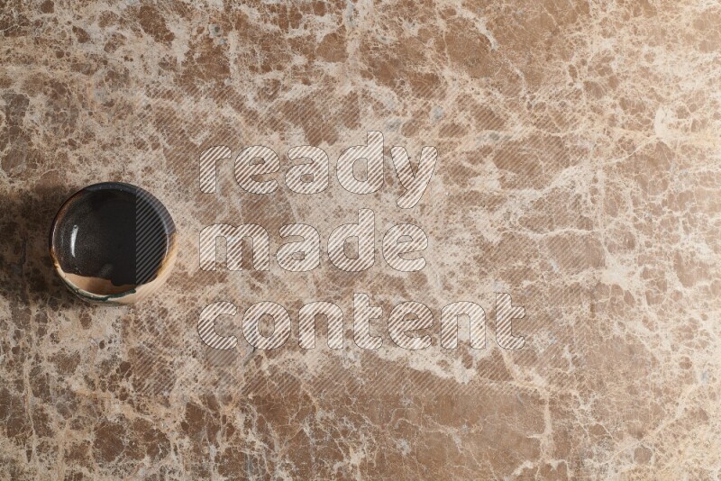 وعاء فخاري متعدد الألوان على خلفية من الرخام البيج