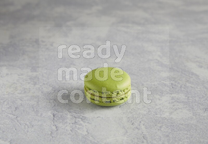 45º Shot of Yellow Lime macaron on white  marble background