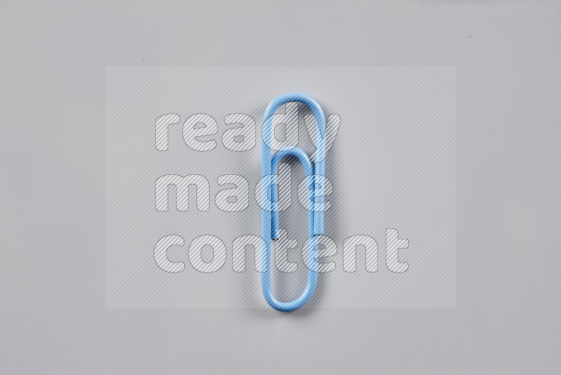 Blue paperclips isolated on a grey background
