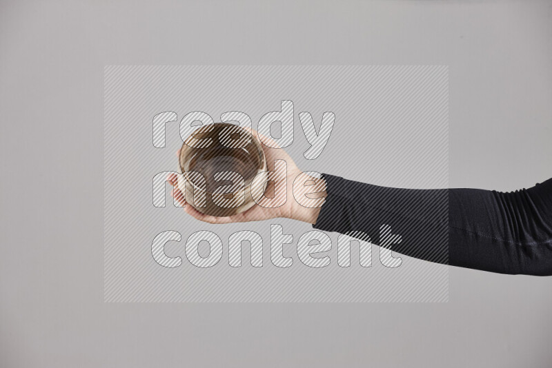 A woman in black abaya holding different pottery essentials in different positions