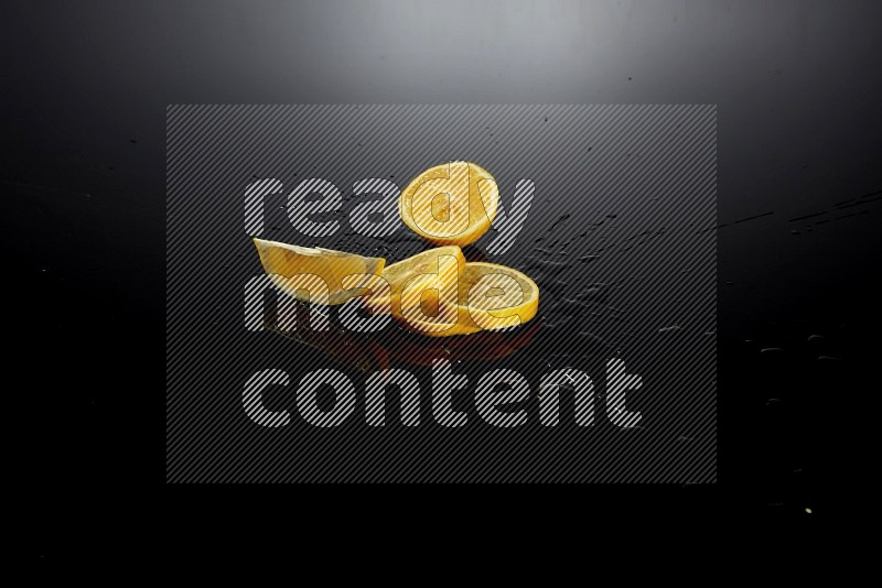 Lemon slices with water drops, and droplets on black background
