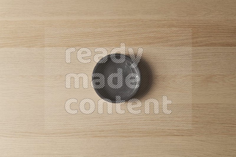 Top View Shot Of A Black Pottery Bowl on Oak Wooden Flooring